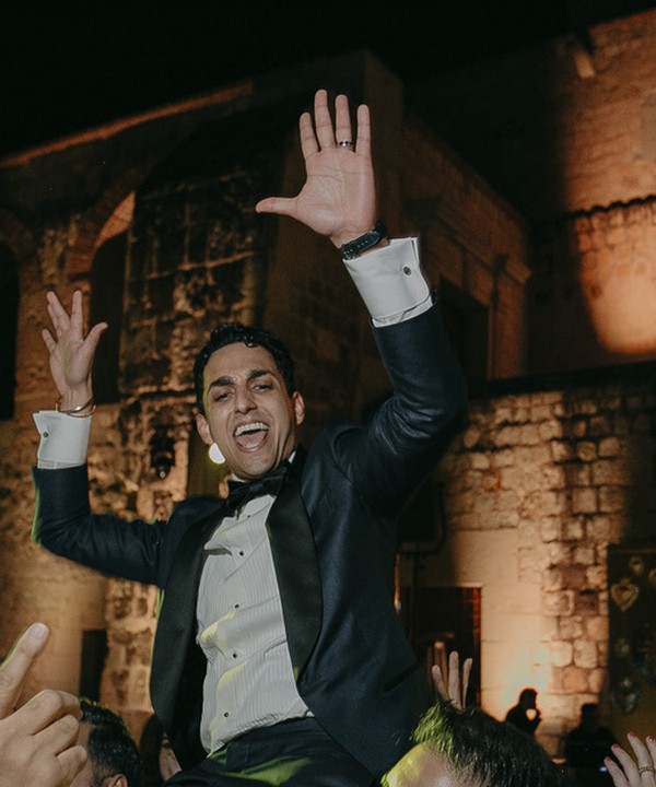 Gurtej celebrating with friends, smiling with his hands in the air